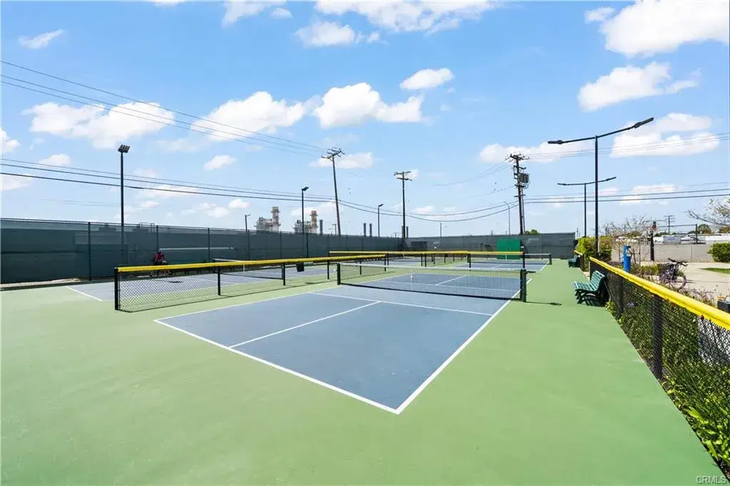Tennis courts at Leisure World community featuring low-impact exercise opportunities, surrounded by a vibrant outdoor setting and blue sky.