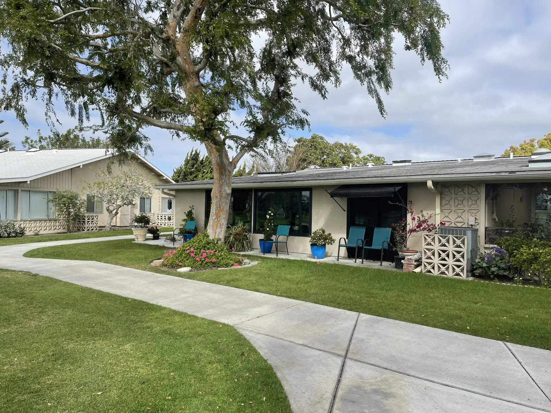 Leisure World Seal Beach homes featuring landscaped lawns, walkways, and outdoor seating areas, emphasizing community living for seniors.