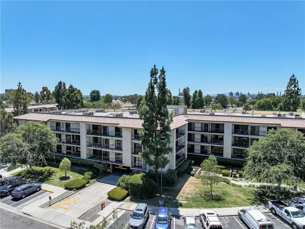 Aerial view of Leisure World Seal Beach retirement community building with landscaped gardens and parking, highlighting maintenance-managed housing for active seniors.
