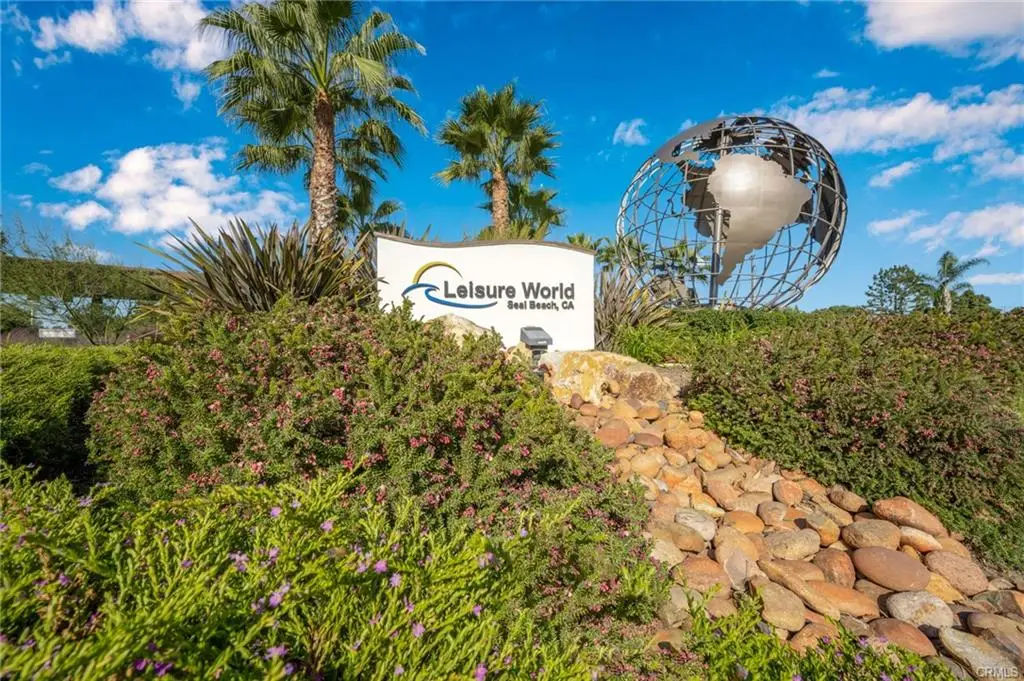 Leisure World Seal Beach entrance sign with landscaped gardens and globe sculpture, emphasizing community amenities for active seniors.