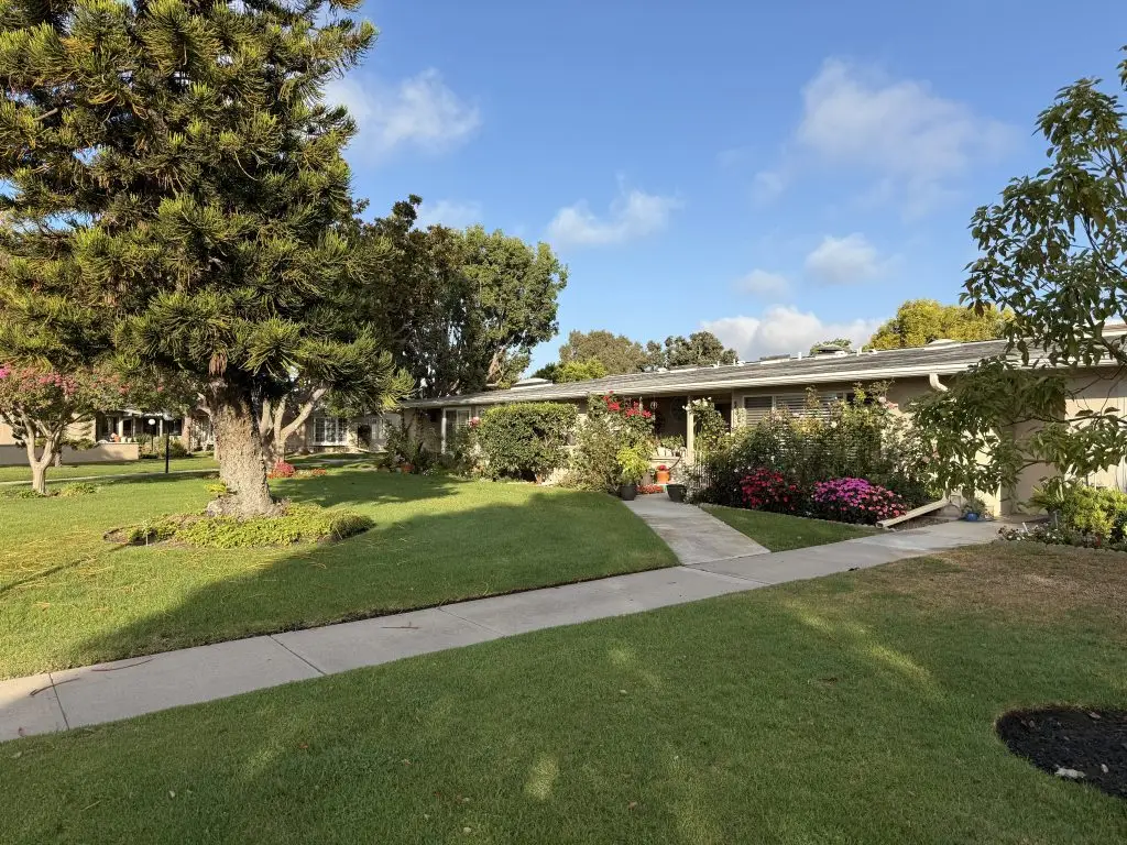 Landscape view of Leisure World Seal Beach featuring well-maintained gardens, pathways, and residential units, showcasing the community's vibrant outdoor living environment.
