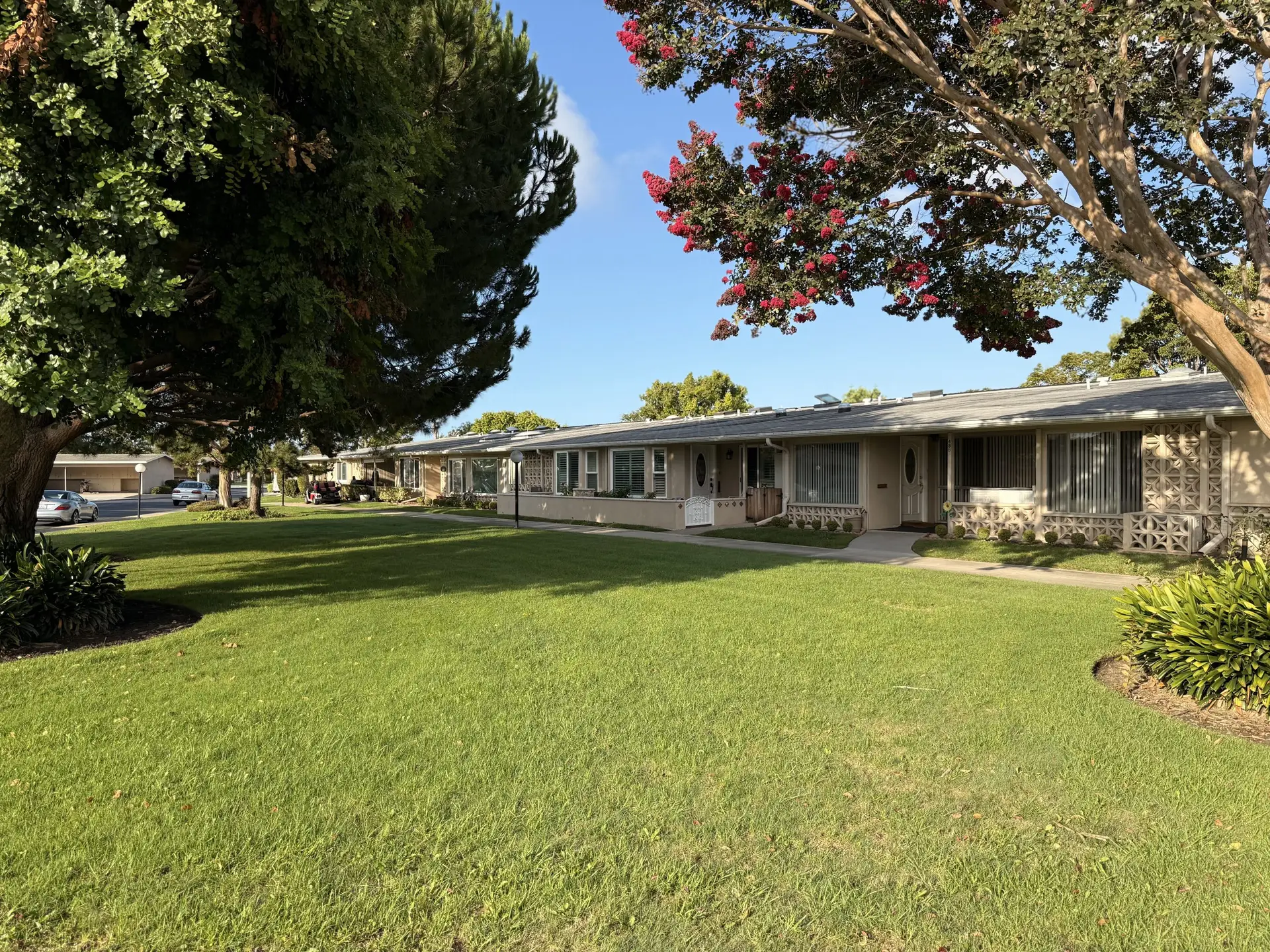 Leisure World Seal Beach 55+ community showcasing well-maintained homes, lush green lawns, and vibrant landscaping, emphasizing a welcoming, active lifestyle for seniors.