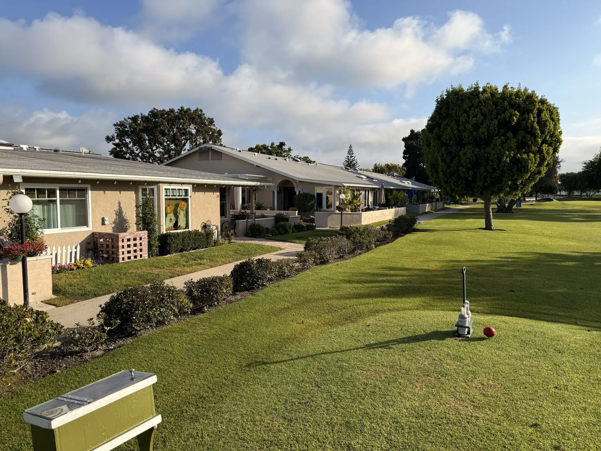 Leisure World Seal Beach golf course view featuring well-maintained lawns, residential buildings, and a scenic landscape, supporting an active 55+ lifestyle.