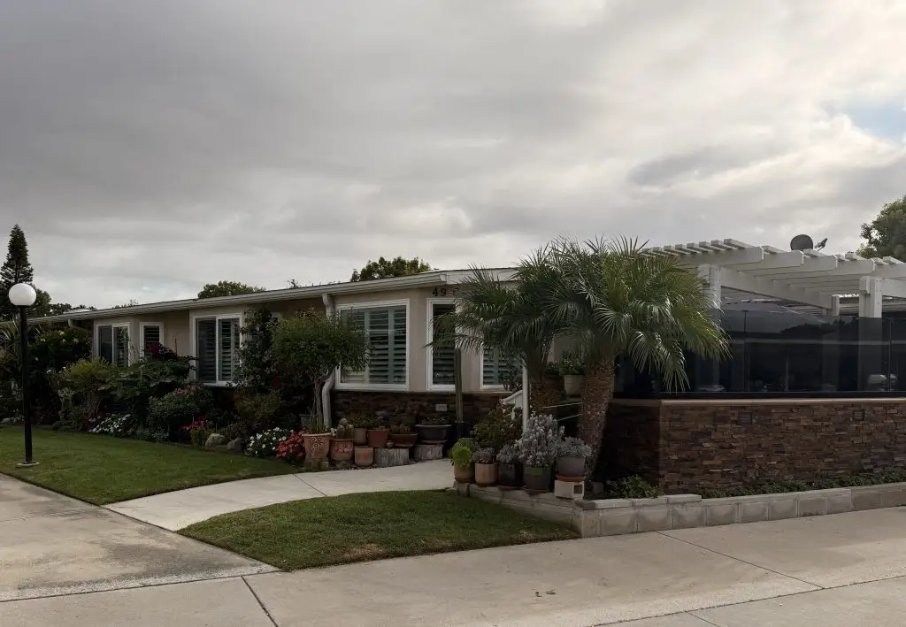 Leisure World Seal Beach residence with landscaped garden, palm trees, and modern exterior, showcasing a well-maintained property in a 55+ community.