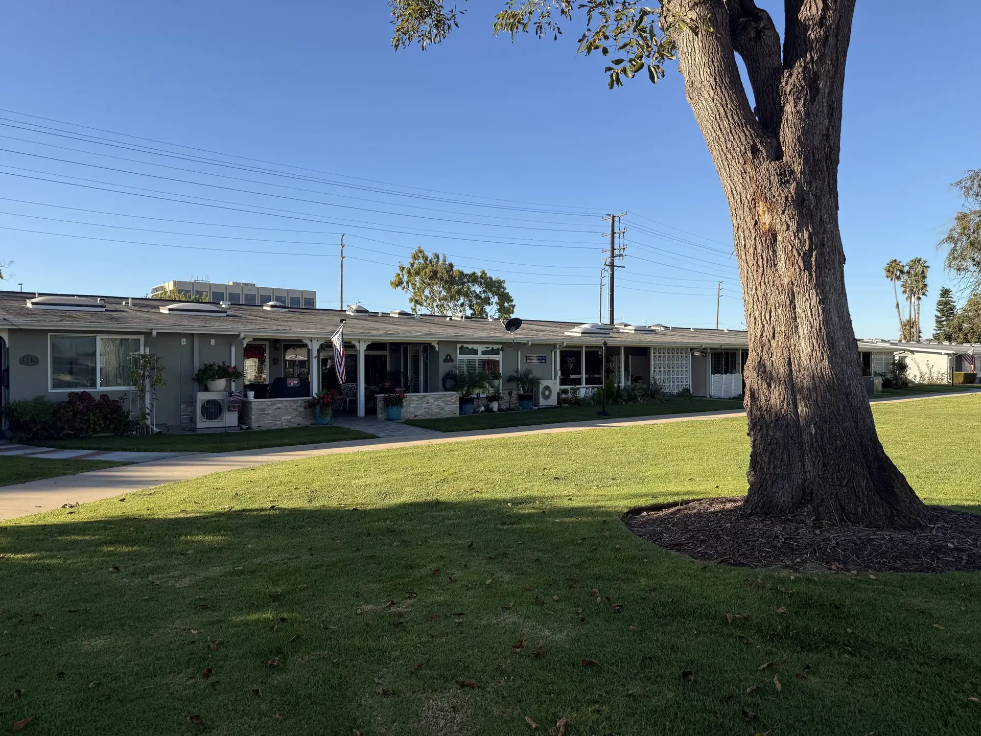 Leisure World Seal Beach community housing with landscaped lawns, trees, and amenities, illustrating property types influencing real estate values.