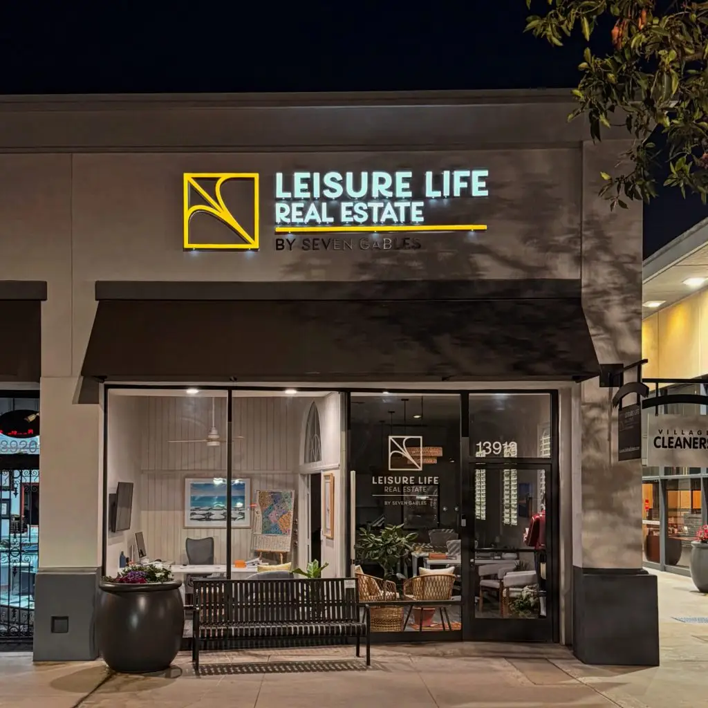 Leisure Life Real Estate office exterior at night, featuring illuminated signage, modern design, and welcoming atmosphere, relevant to real estate services for the 55+ community in Seal Beach.