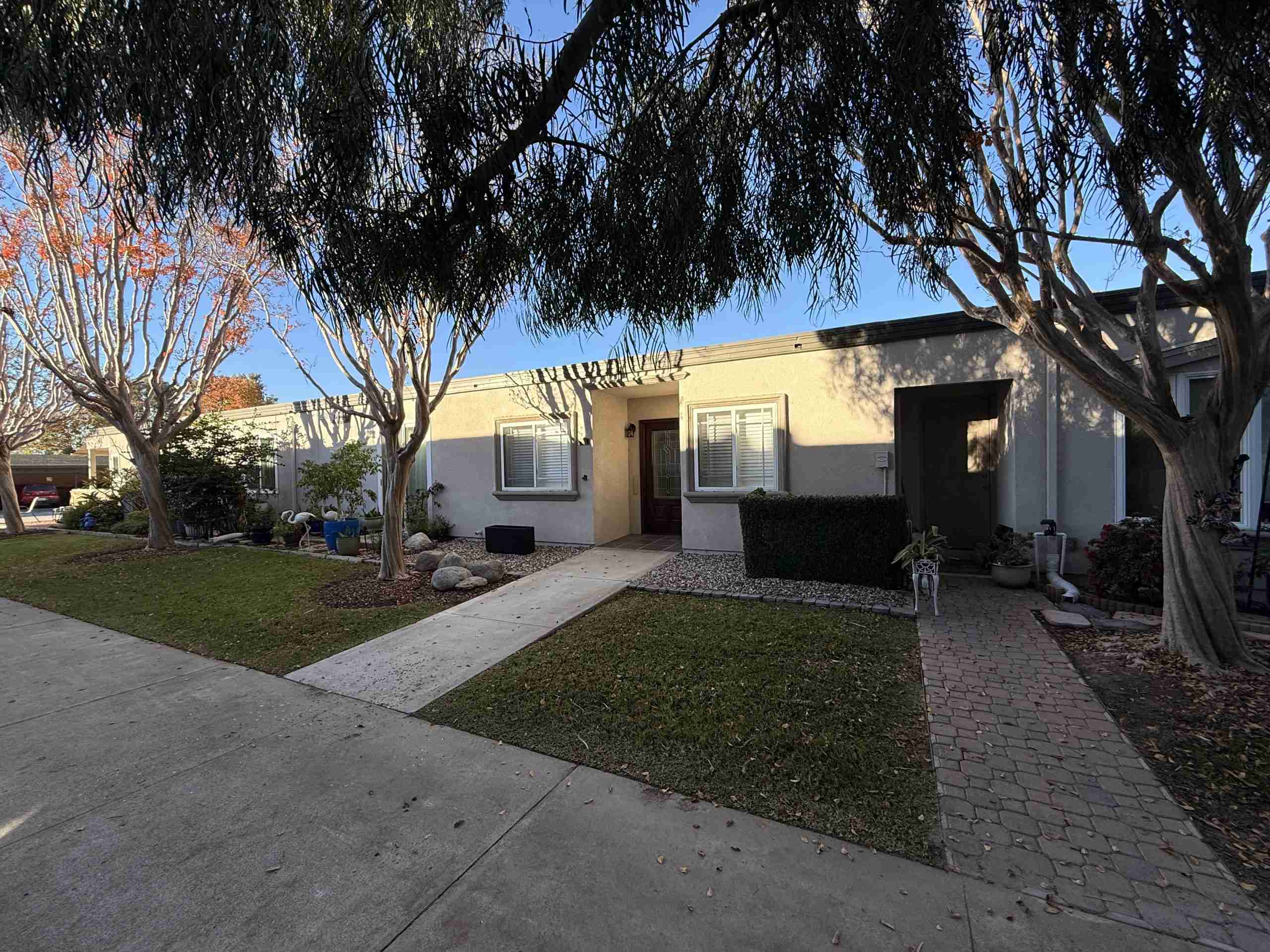 Leisure World Seal Beach property exterior featuring well-maintained landscaping, pathways, and residential units, illustrating the community's appeal for 55+ living.