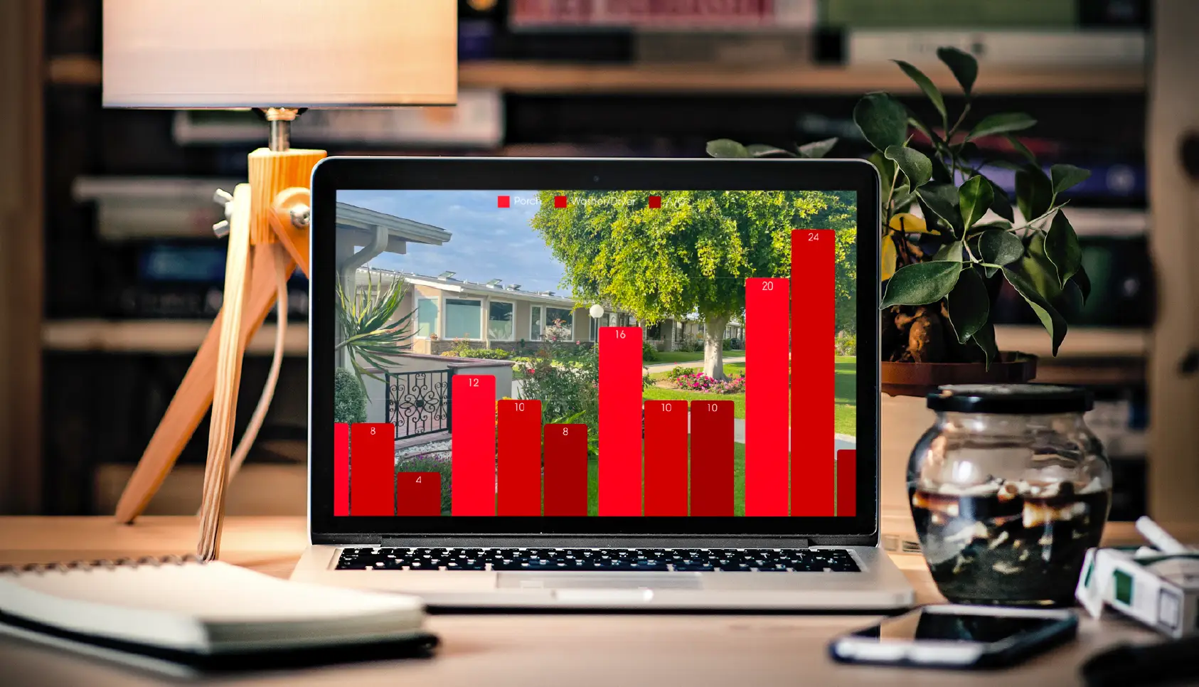 Laptop displaying a bar graph with red bars overlaid on a scenic view of Leisure World Seal Beach, highlighting real estate sales data trends.