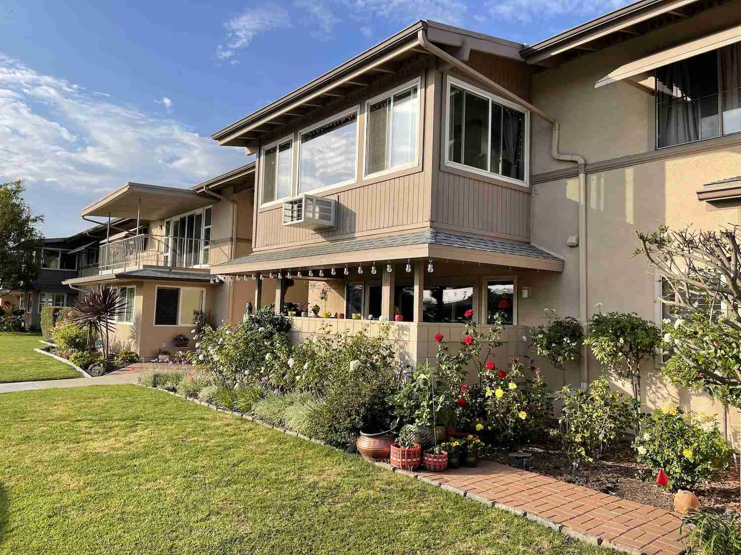 Leisure World Seal Beach home exterior with landscaped yard and patio, showcasing community living.