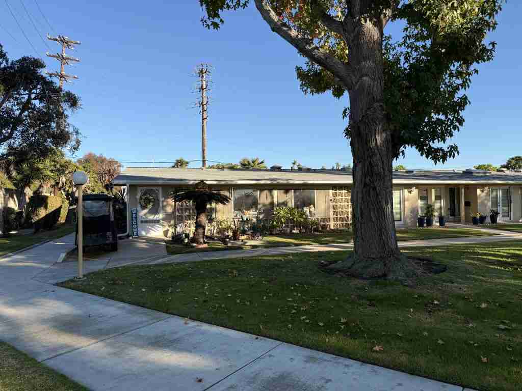 Leisure World Seal Beach cooperative unit and condominium property with mature landscaping and a well-maintained exterior.